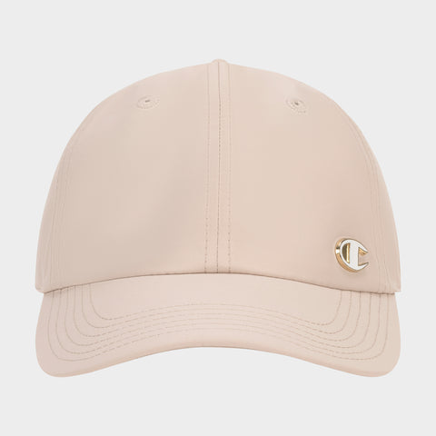 The Champion Lifestyle Sport Adjustable Baseball Cap in beige features visible stitching, a small gold C logo pin on the front left, a curved brim, and two top eyelets—blending classic athletic heritage with modern style.