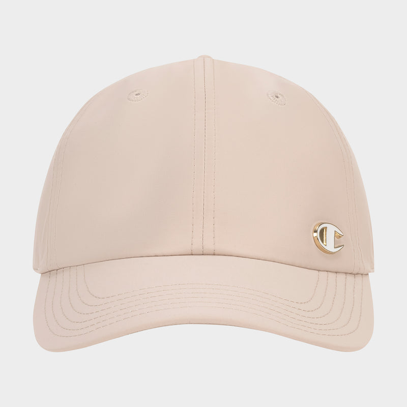 The Champion Lifestyle Sport Adjustable Baseball Cap in beige features visible stitching, a small gold C logo pin on the front left, a curved brim, and two top eyelets—blending classic athletic heritage with modern style.
