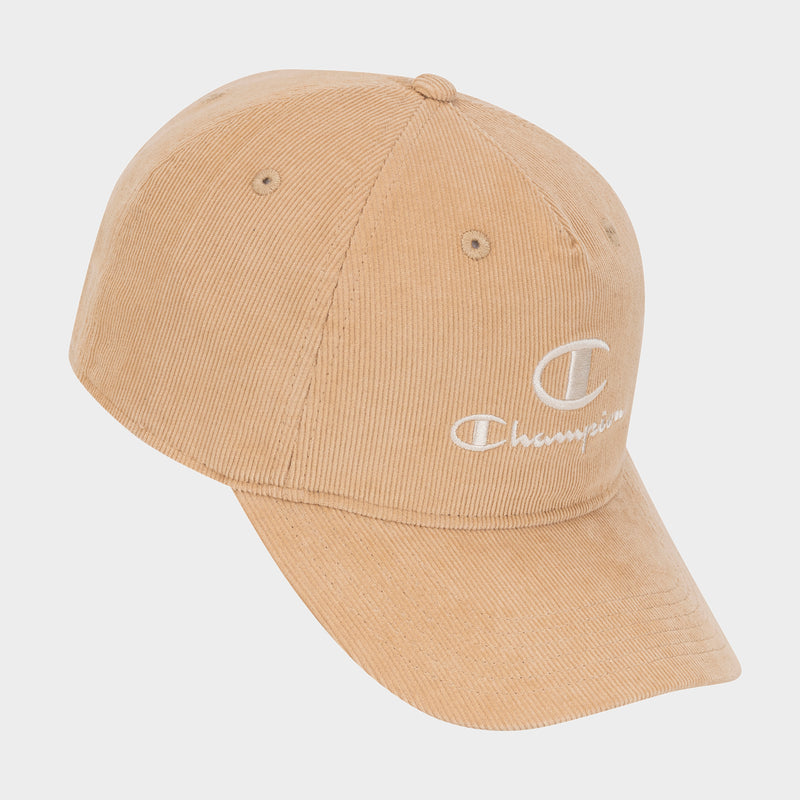 The Champion Pursuit Corduroy Adjustable Cap is a tan cap made from corduroy, featuring a white embroidered Champion logo with a large “C” on the front. This classic cap offers a comfortable snapback closure and is shown against a plain white background.