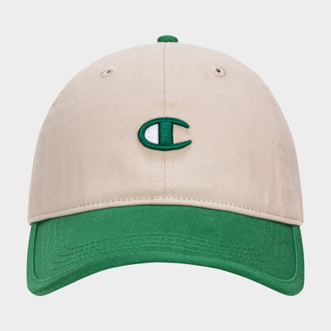 The Champion Briggs Washed Cotton Twill Adjustable Baseball Cap features a beige design with a green brim and a green and white embroidered C logo, crafted from washed cotton twill and shown on a plain white background.