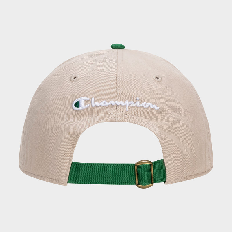 The Briggs Washed Cotton Twill Adjustable Baseball Cap by Champion is shown from the back, featuring a vintage beige look, white embroidered Champion logo, green adjustable strap with gold buckle, and a matching green top button.