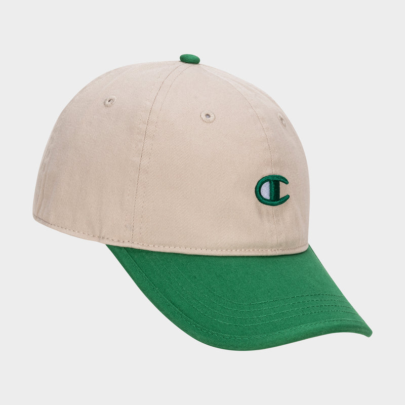 The Champion Briggs Washed Cotton Twill Adjustable Baseball Cap features a beige body, green brim and button, and a green outlined C logo on the front left panel, shown against a white background.