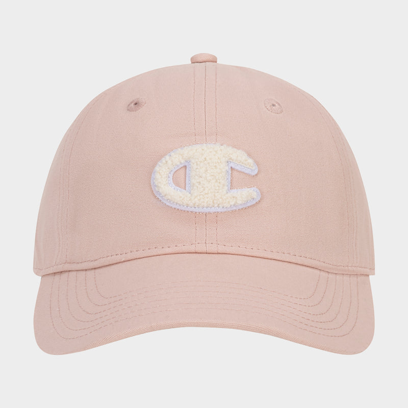 The Amber Chenille Adjustable Cap by Champion features a light pink hue, a textured white chenille patch letter C on the front, and a relaxed fit. It is shown from the front against a plain white background.