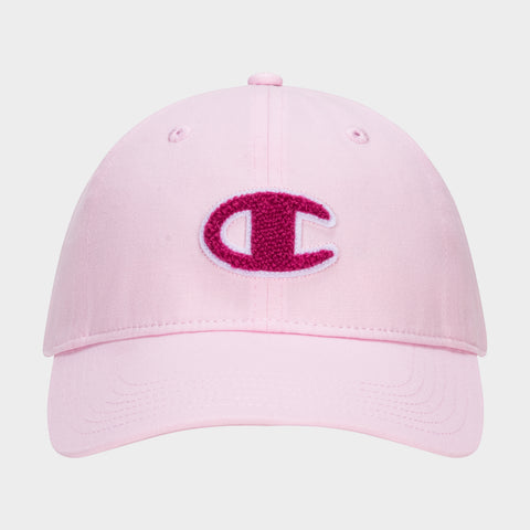 The Champion Amber Chenille Adjustable Baseball Cap in light pink slub canvas features a large, textured dark pink C logo chenille patch outlined in white on the front, with visible stitching and an unconstructed fit.