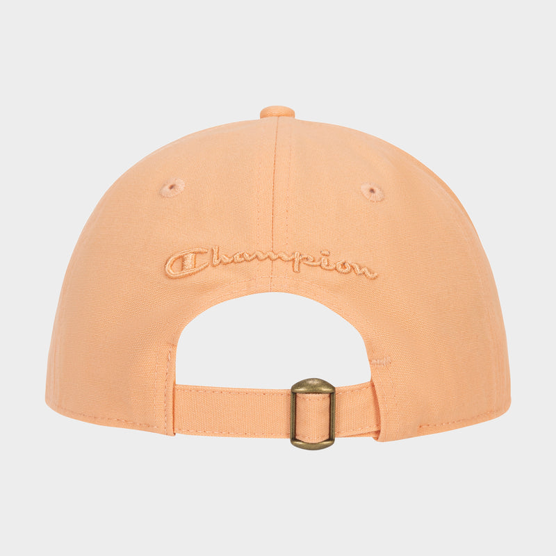The Amber Chenille Adjustable Cap by Champion is shown from the back, featuring “Champion” embroidered above the adjustable strap with a brass-colored metal buckle. Designed with a relaxed fit, this peach-colored cap offers both comfort and effortless style.
