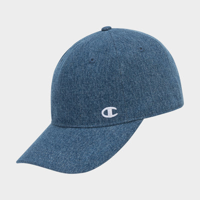 The Glen Denim Adjustable Baseball Cap by Champion is a blue denim hat with a curved brim and a small white embroidered C logo on the front left, shown against a plain light gray background.