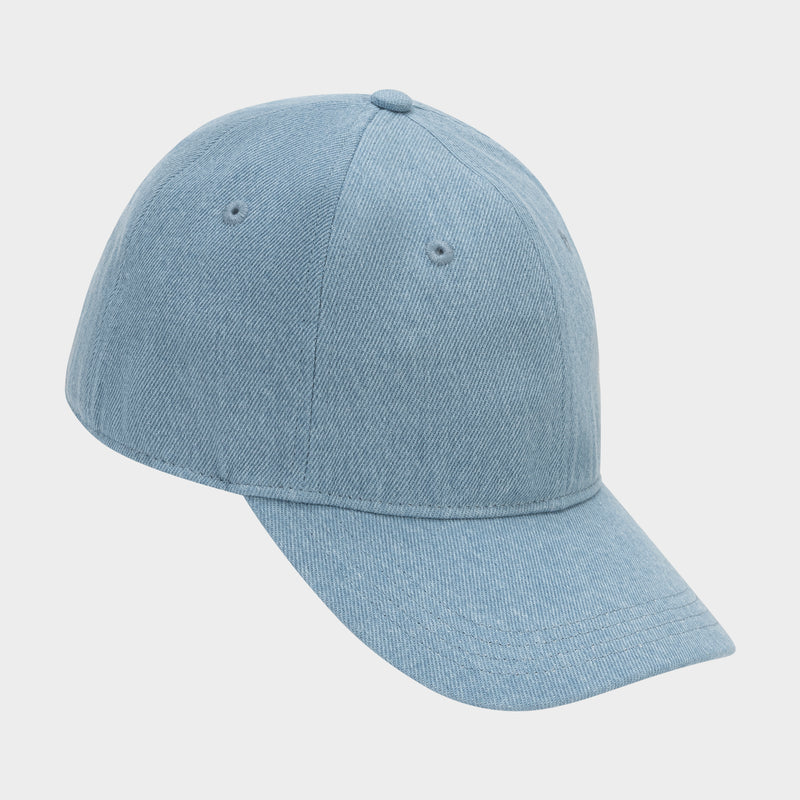 The Glen Denim Adjustable Baseball Cap by Champion features light blue denim, a curved brim, visible stitching, and two ventilation holes on each side. Shown against a plain white background.