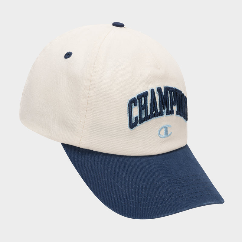 The Amor Adjustable Baseball Cap by Champion features cream-colored cotton twill, a navy blue brim and top button, with "CHAMPION" and the logo embroidered in blue on the front.