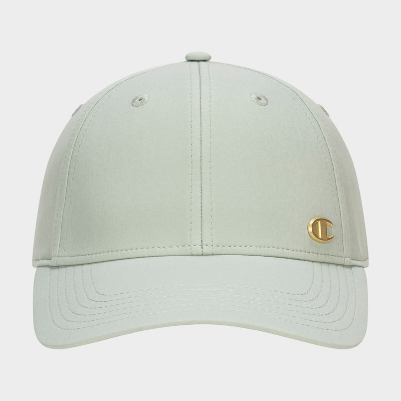 Front view of the Champion Ponytail Baseball Cap in light sage green, featuring a curved brim, performance stretch fabric, and a small gold C logo emblem on the lower right front panel.