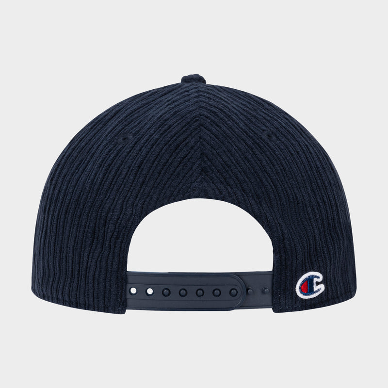 The back of the Stephen Adjustable Cap by Champion, crafted in dark blue corduroy, features an adjustable strap and a small C logo on the lower right side, showcasing the signature style of a Champion cap.
