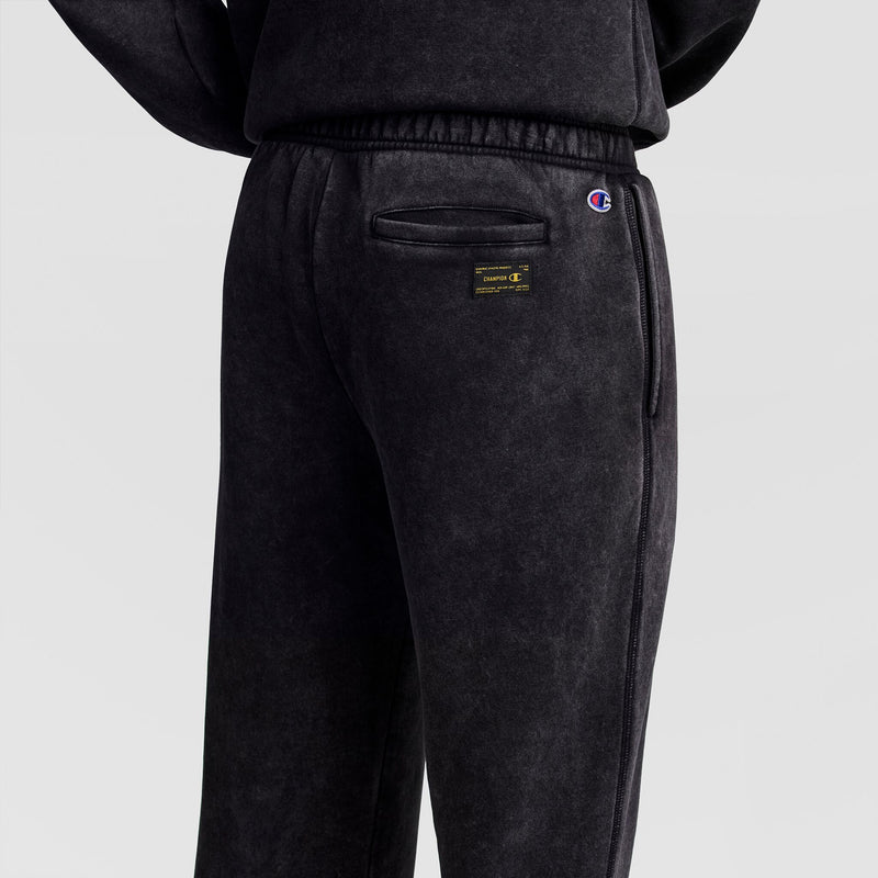 Back view of dark grey Mineral Wash Open Hem Pant featuring a back pocket, a rectangular Champion brand label, and a small logo embroidered near the waist.