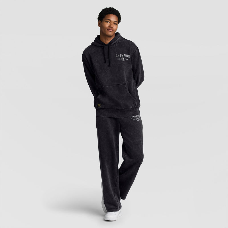 A person wearing a dark grey mineral wash hooded sweatshirt and matching Champion Mineral Wash Open Hem Pant.