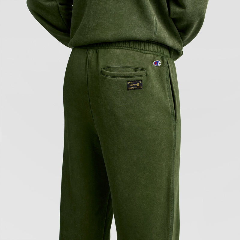 Olive green Champion Mineral Wash Open Hem Pant featuring an elastic waistband, a back pocket with a rectangular brand patch, and a small embroidered logo near the hip for a vintage look.