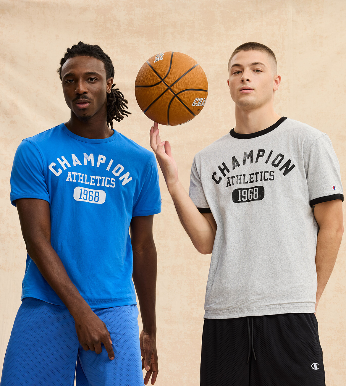 Two people wearing Champion Athletics t-shirts with a basketball between them on a beige background.