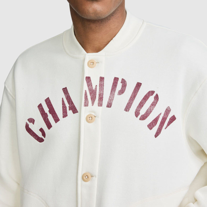 Off-white Champion Fleece Baseball Jacket with the word CHAMPION in distressed dark red lettering across the chest.