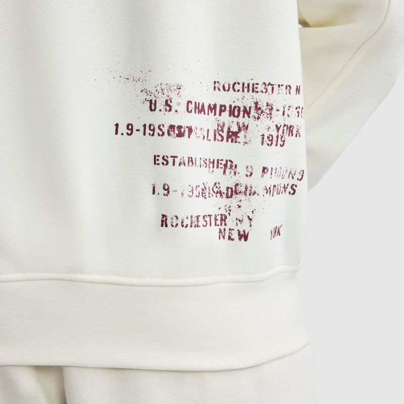 Cream-colored Champion Fleece Baseball Jacket with distressed, dark red text on the side featuring Rochester, New York and Established 1919.