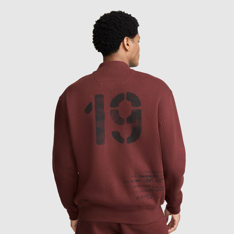 Back view of a person wearing a maroon Champion Fleece Baseball Jacket, featuring a large black 19 and smaller printed text on the back.