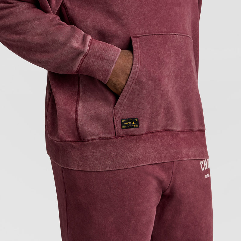 A person wearing a vintage Mineral Wash Pullover Hoodie, C Patch Logo with a kangaroo pocket and a small rectangular logo patch, paired with matching sweatpants.