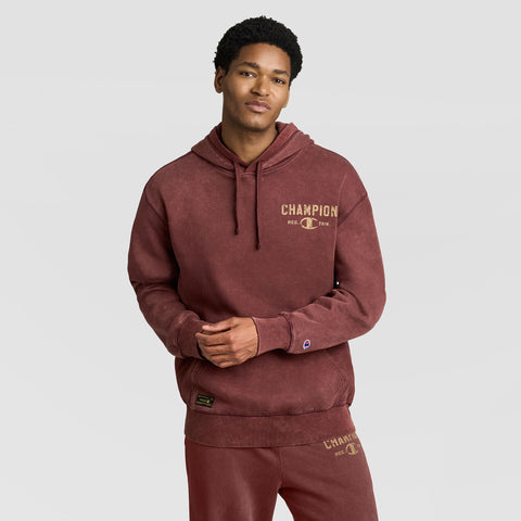 A person wearing a maroon Mineral Wash Pullover Hoodie, C Patch Logo with a distressed chest logo and matching sweatpants.