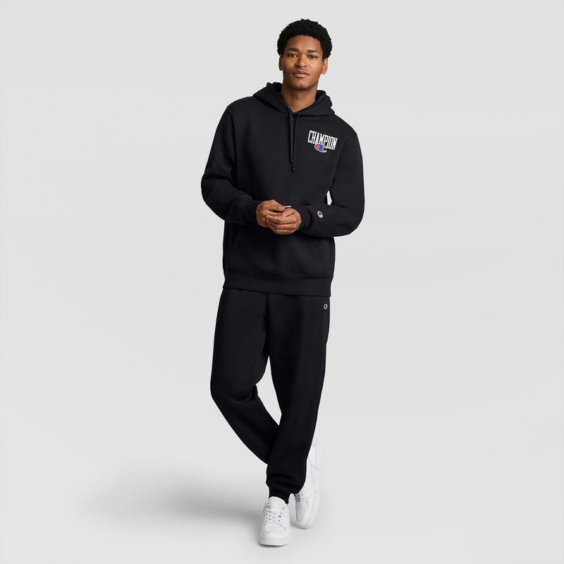 A person wearing a Champion Fleece Hoodie, Left Chest Graphic and matching black sweatpants.