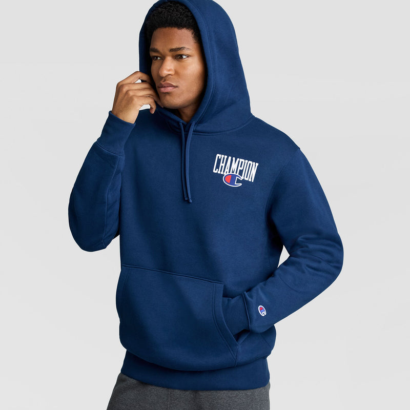A person wears a navy blue Fleece Hoodie, Left Chest Graphic by Champion, featuring a white logo on the left chest and a small embroidered logo on the left cuff.