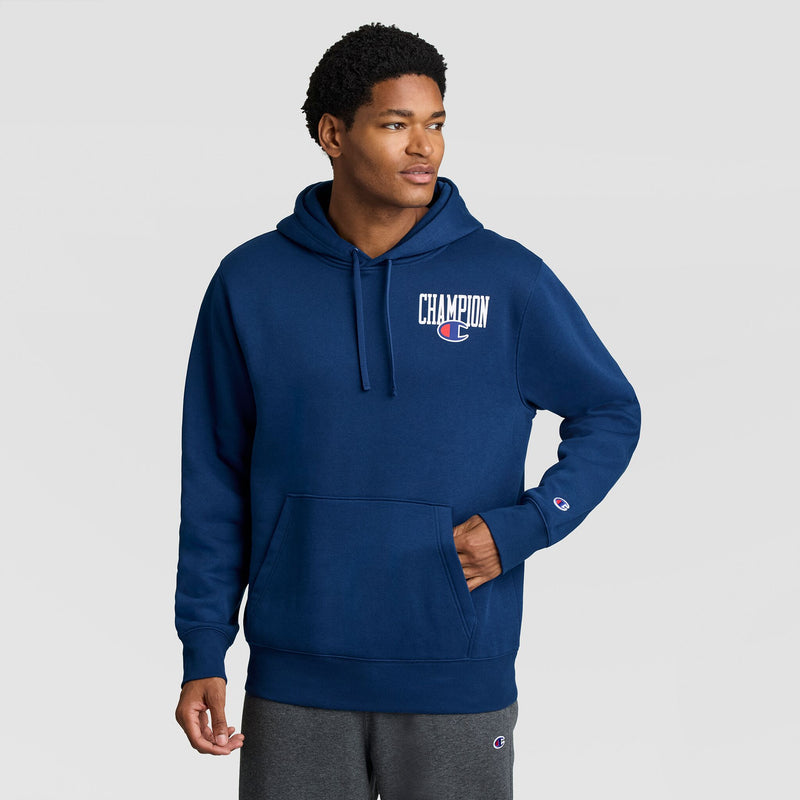 A man wearing a blue Champion Fleece Hoodie, Left Chest Graphic, featuring a logo on the left chest and a small emblem on the sleeve.