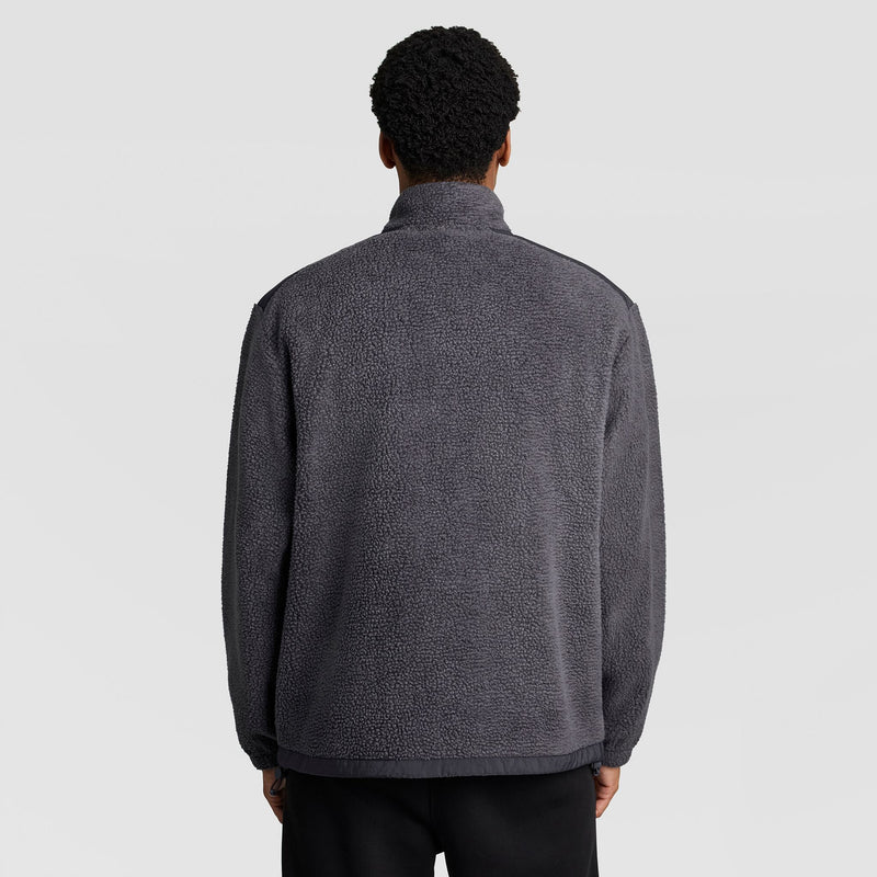 Back view of a person wearing a grey Champion Polar Fleece Quarter Zip with a textured finish, a high collar, and dark trim at the hem.