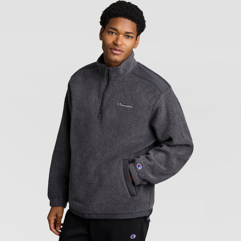A man wearing a charcoal grey Champion Polar Fleece Quarter Zip, featuring a high collar and a chest pocket.