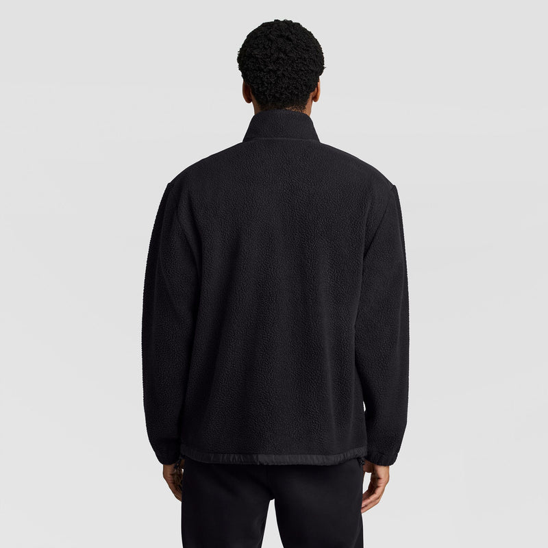 Back view of a person wearing a black textured Champion Polar Fleece Quarter Zip with a high collar.
