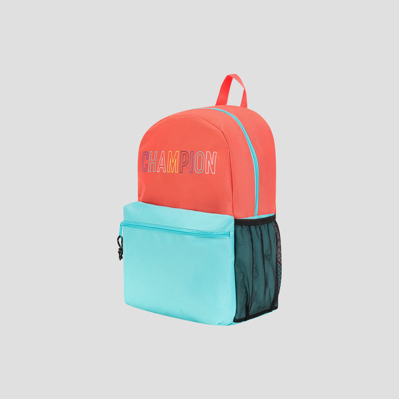 A Champion Kids’ Merit Backpack with a coral red top and light blue bottom, featuring bold CHAMPION text, a front pocket, black mesh side pocket, and a red handle is photographed on a plain light gray background.