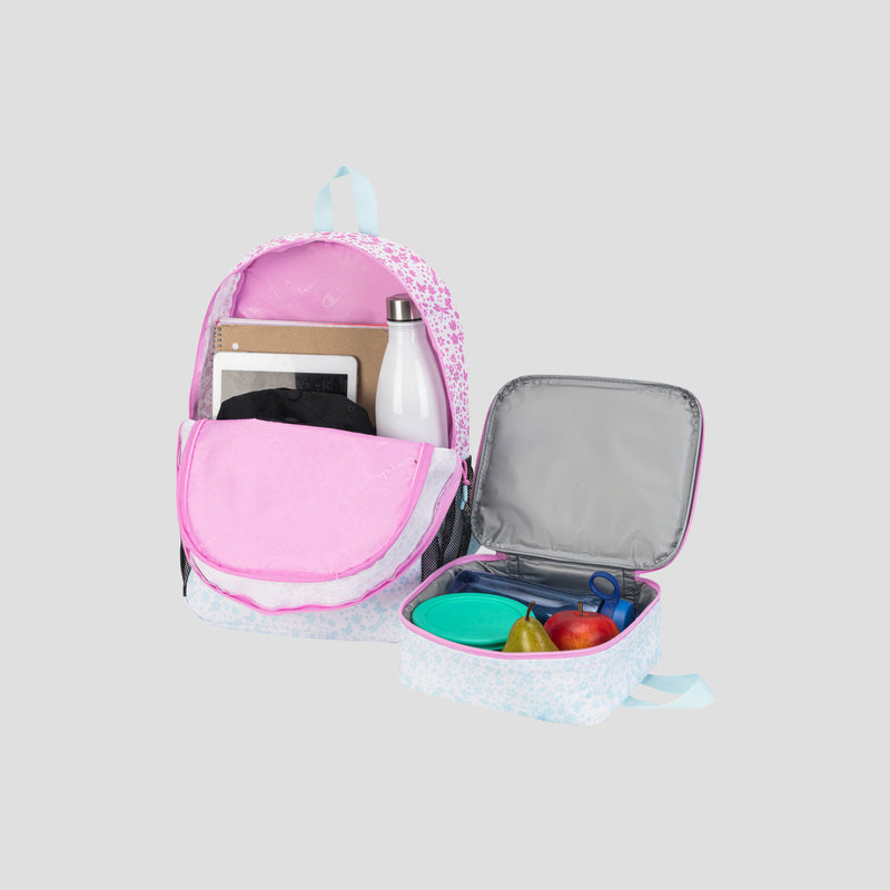 A Champion Kids’ Mode Lunch Kit & Backpack Combo in pink and white—shown with a water bottle, tablet, and notebook inside the backpack—sits beside an open insulated lunch kit holding a green container, apple, pear, and blue fork, all arranged on a light gray background.