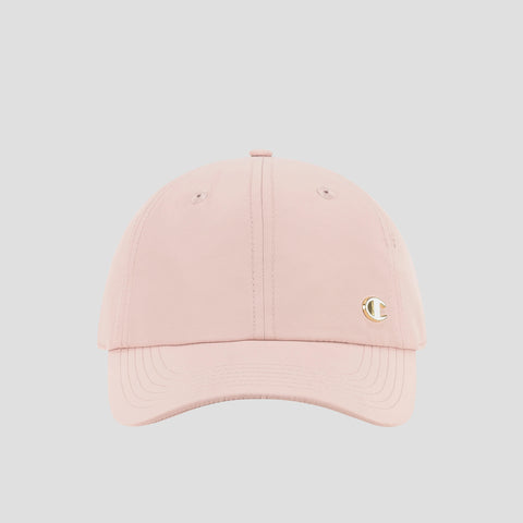 A light pink Champion Lifestyle Sport Adjustable Baseball Cap, featuring a small gold C logo on the front left side that highlights the brand’s athletic heritage, is displayed against a plain light gray background.