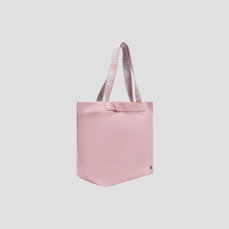 A pink Miller Coated Shopper Tote by Champion, featuring weather-resistant material and light pink shoulder straps with CHAMPION written on them, is displayed against a plain white background. This spacious bag provides ample room and convenient organizational pockets to keep your essentials neatly organized.