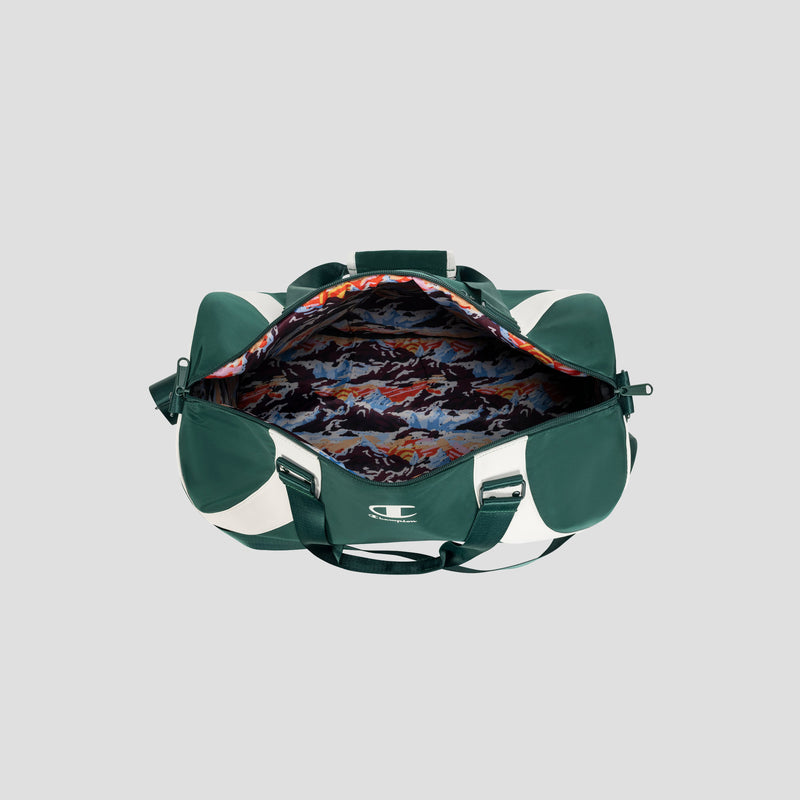 The Champion Oracle Duffel Bag, shown with its top open to reveal a vibrant mountain-patterned interior lining, features a green and white design and is displayed on a plain gray background.