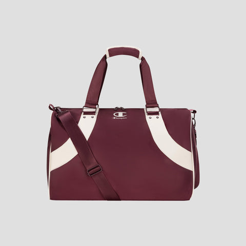 The Champion Oracle Duffel Bag in maroon, featuring white curved stripes, top handles, a shoulder strap, and a small Champion logo on the front, is displayed against a plain light gray background. This versatile gym bag is ideal for both workout sessions and travel.