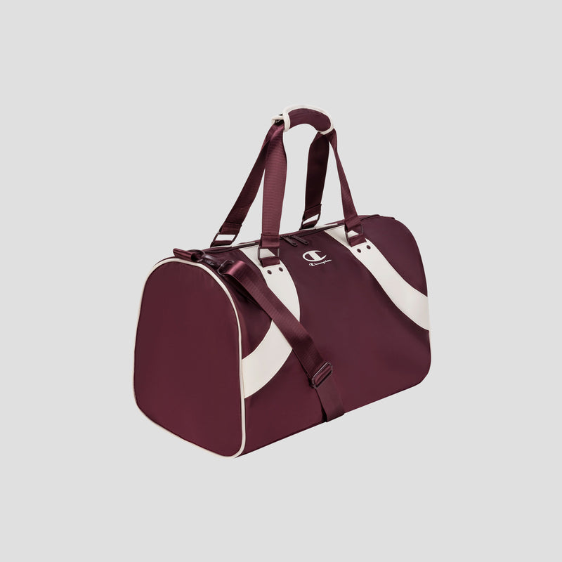 The Champion Oracle Duffel Bag, featuring a maroon body with white curved stripes, white handles, and maroon shoulder straps, is displayed on a plain light gray background.