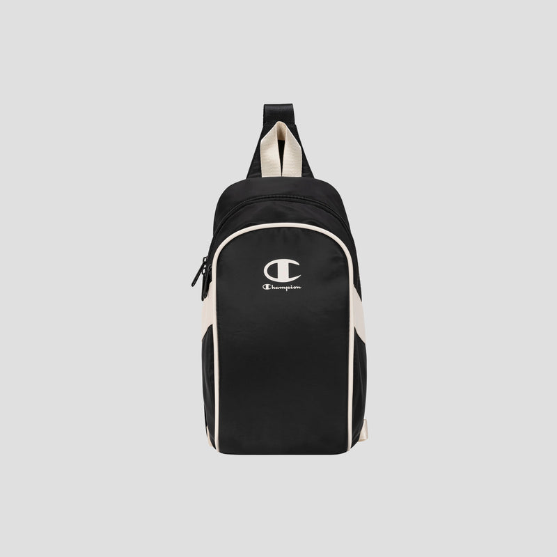 The Champion Oracle Sling Pack, shown in black and white against a plain light gray background, is perfect for use as a gym bag and features a front zipper pocket, white Champion logo on the front, and a top handle.