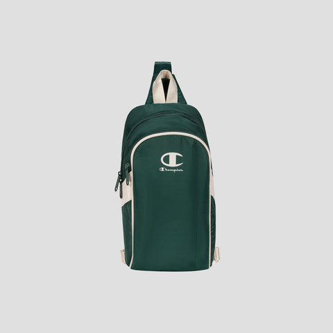 The Champion Oracle Sling Pack, shown in dark green and white with a front zipper pocket and top handle, is displayed against a plain light gray background.