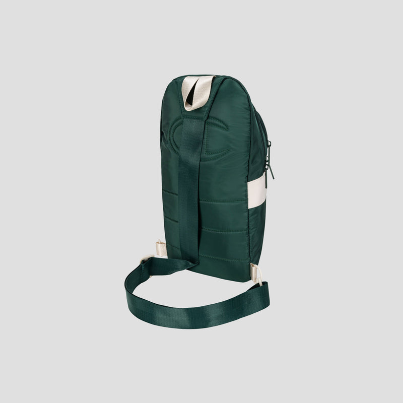 A dark green Champion Oracle Sling Pack crossbody bag with a wide adjustable strap, white accent along the top, and simple stitching, displayed against a plain light gray background.