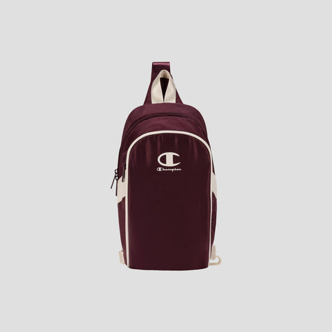 Oracle Sling Pack by Champion in maroon with white logo and accents, featuring a single shoulder strap and front zipper pocket, displayed on a plain light background—the perfect crossbody bag for the gym or everyday use.