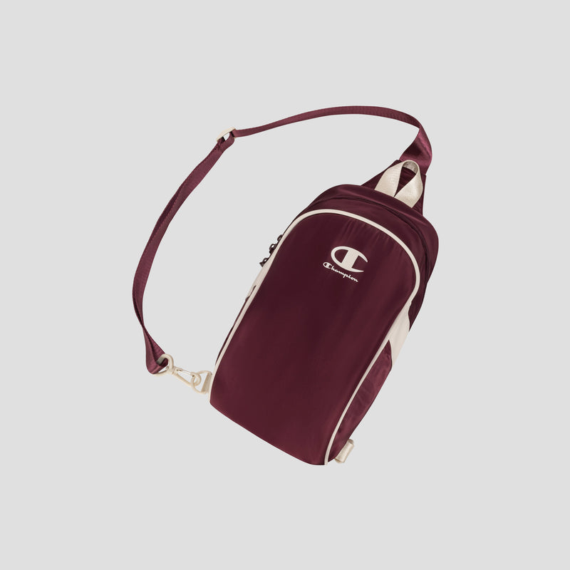 Oracle Sling Pack by Champion in maroon and white, featuring an adjustable strap, zippered main compartment, and side pocket, displayed on a light gray background.
