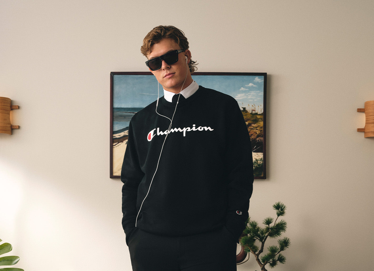 Man wearing a powerblend sweater in a room