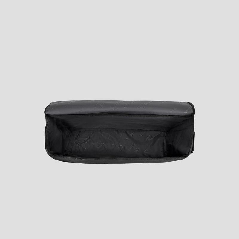 The Champion Phase Messenger Bag, shown from above, features a black rectangular design with an empty, spacious interior and a subtle patterned lining, set against a plain light gray background.