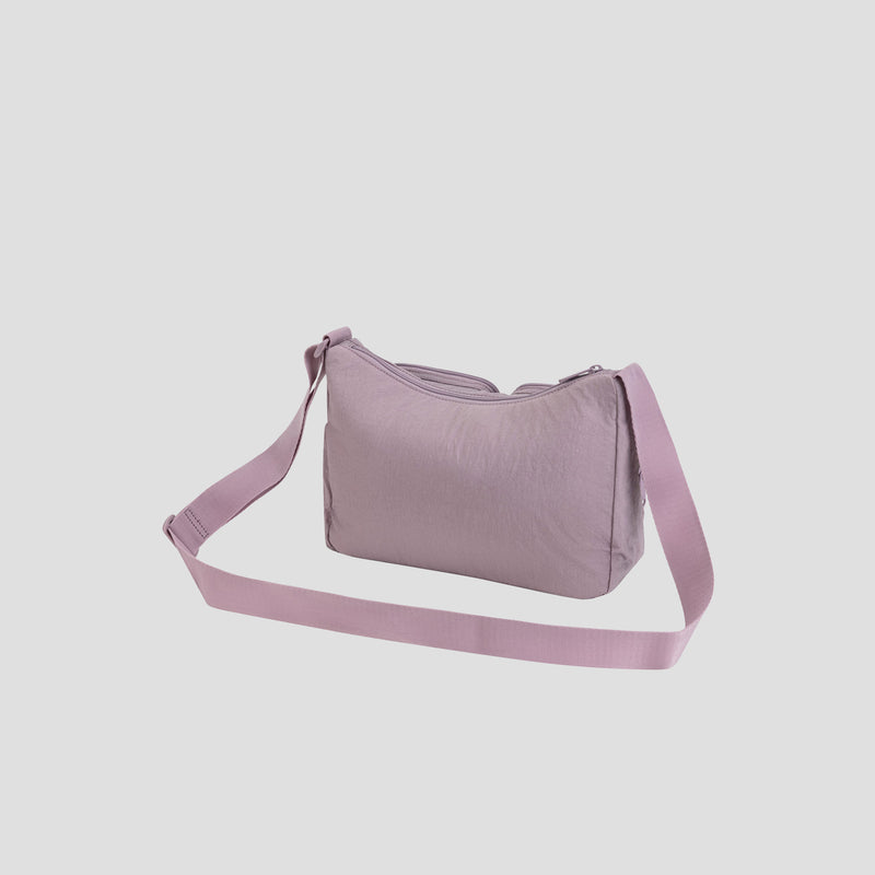 The Champion Quartz Small Messenger Bag, shown in light purple and made from lightweight nylon, features a wide adjustable strap and is displayed against a plain white background.