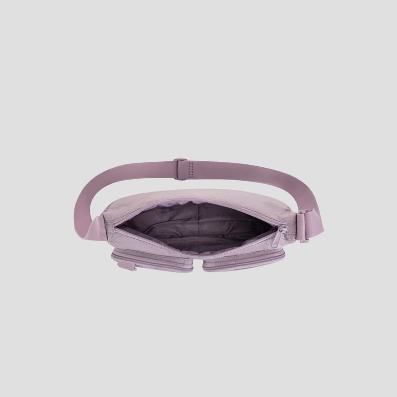 A top view of the open Champion Quartz Small Messenger Bag in light purple, made from lightweight nylon with a wide strap, showcasing its empty, spacious interior and zippered compartments against a plain gray background—ideal as a stylish crossbody messenger bag for travel or everyday use.