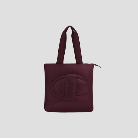 Introducing the Champion Quilted Billie Tote—a stylish burgundy quilted bag featuring two sturdy handles, a secure zipper closure, and a large embossed C design on the front. Set against a plain light gray background, this tote is perfect for everyday use.