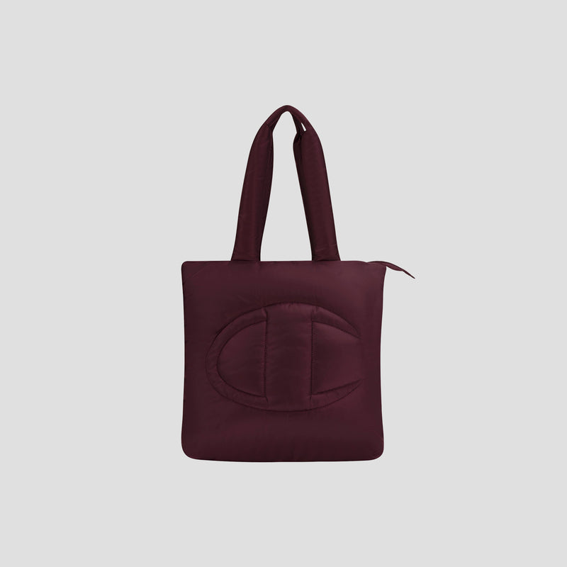 Introducing the Champion Quilted Billie Tote—a stylish burgundy quilted bag featuring two sturdy handles, a secure zipper closure, and a large embossed C design on the front. Set against a plain light gray background, this tote is perfect for everyday use.
