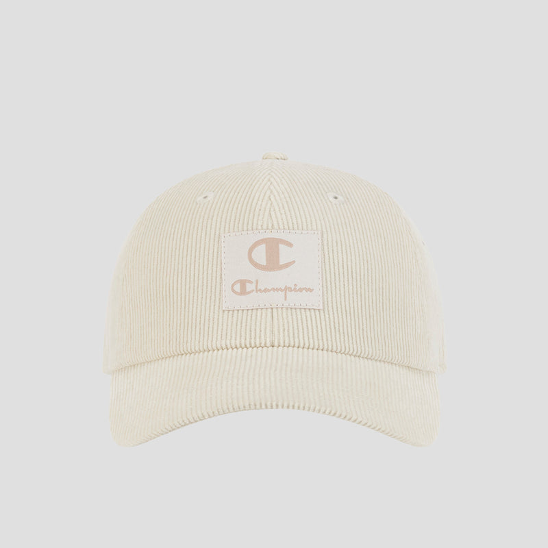 Front view of the Ridge Corduroy Adjustable Cap by Champion, shown in a cream color with a beige Champion logo patch on the front panel, featuring an adjustable back closure for a comfortable fit, set against a plain light background.