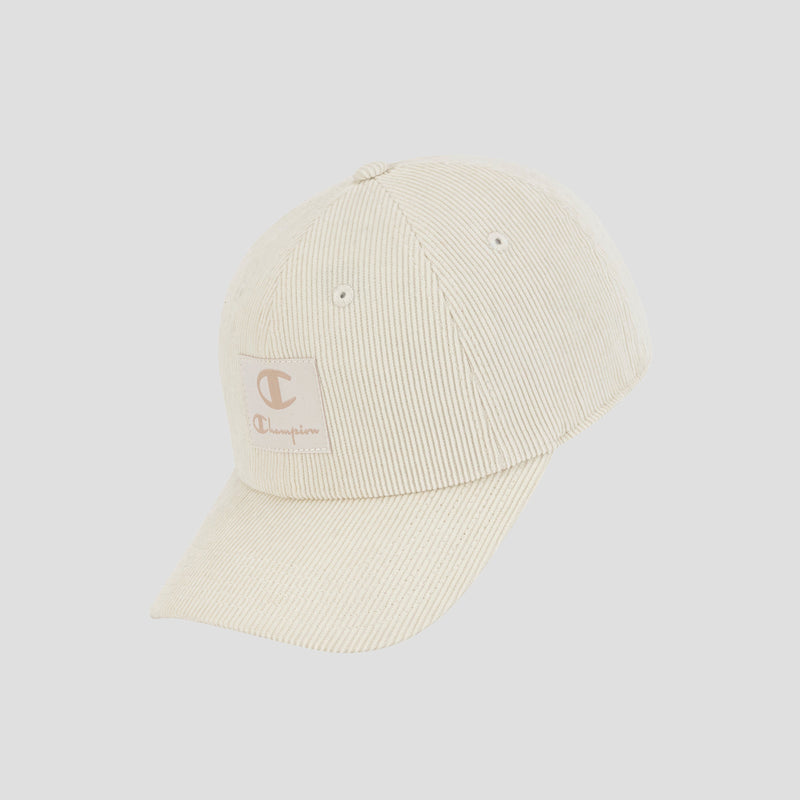 The Ridge Corduroy Adjustable Cap by Champion features a beige corduroy design with a curved brim and a small rectangular Champion logo patch on the front. This vintage-inspired baseball cap comes with an adjustable back closure for a comfortable fit and is displayed against a plain light gray background.