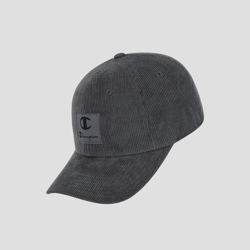 The Champion Ridge Corduroy Adjustable Cap features a dark gray vintage corduroy design in a relaxed fit, complete with a curved brim and a front patch displaying a black “C” and the Champion script logo. This baseball cap includes an adjustable back closure for a personalized fit and is shown against a plain light background.
